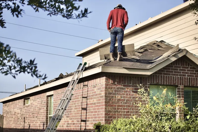 Professional roofer working on a residential roof in Finney